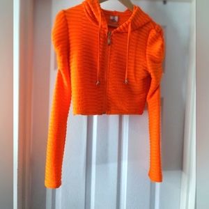 Neon orange cropped hoodie with drawstring and ruched sleeves. Cute!